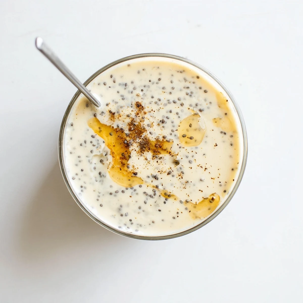 Creamy Greek yogurt banana smoothie poured into a tall glass with fresh banana slices on the rim