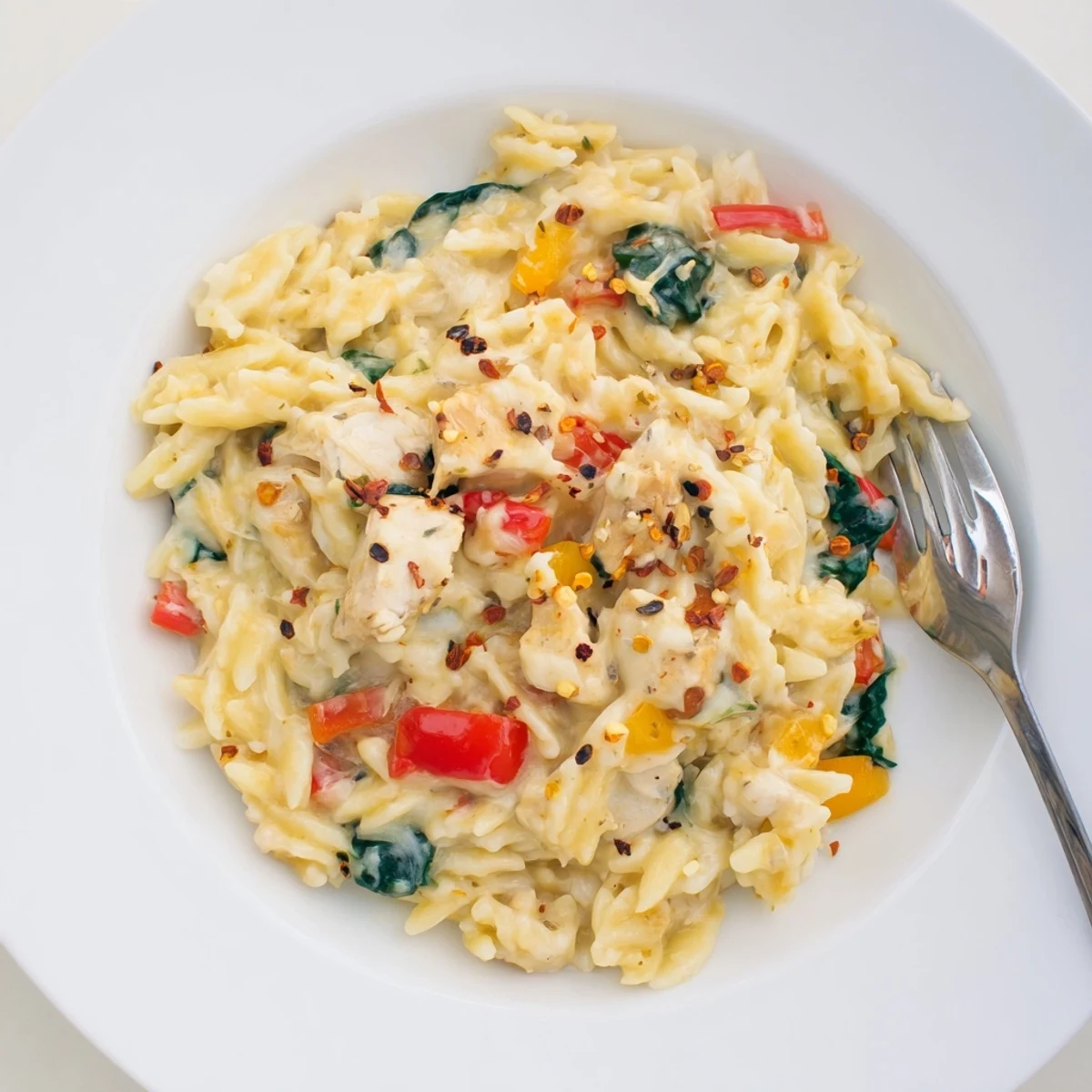 Creamy thirty minute cheesy chicken risoni skillet topped with melted mozzarella and fresh Parmesan cheese