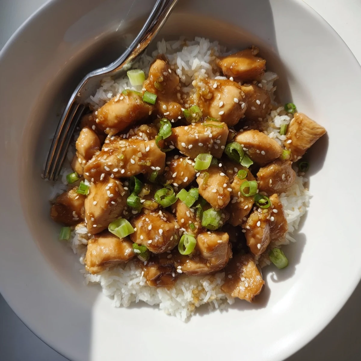 Slow cooker teriyaki chicken coated in glossy dark sauce over fluffy white rice