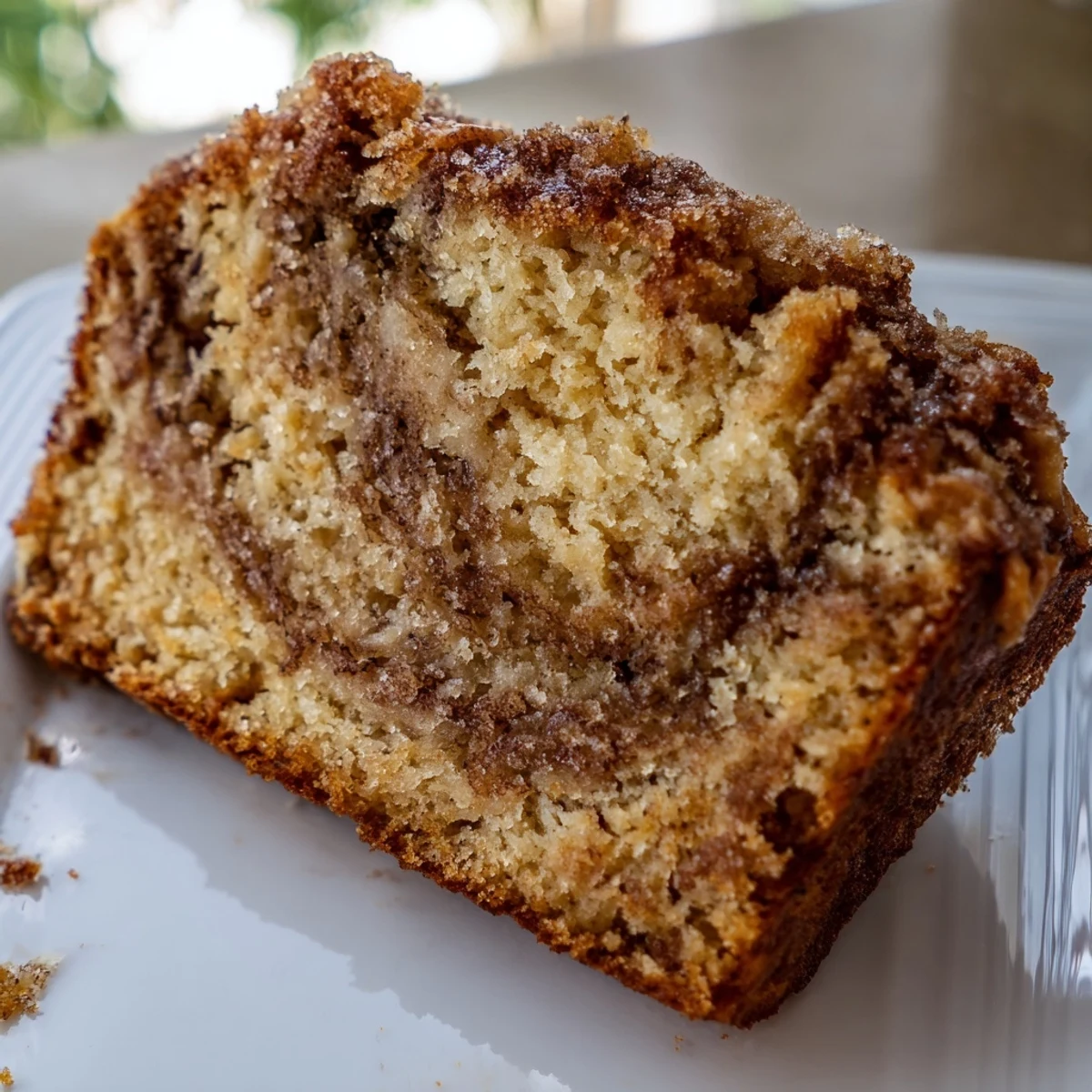 Warm Cinnamon Sugar Swirl Banana Bread served on wooden board with melting butter on top