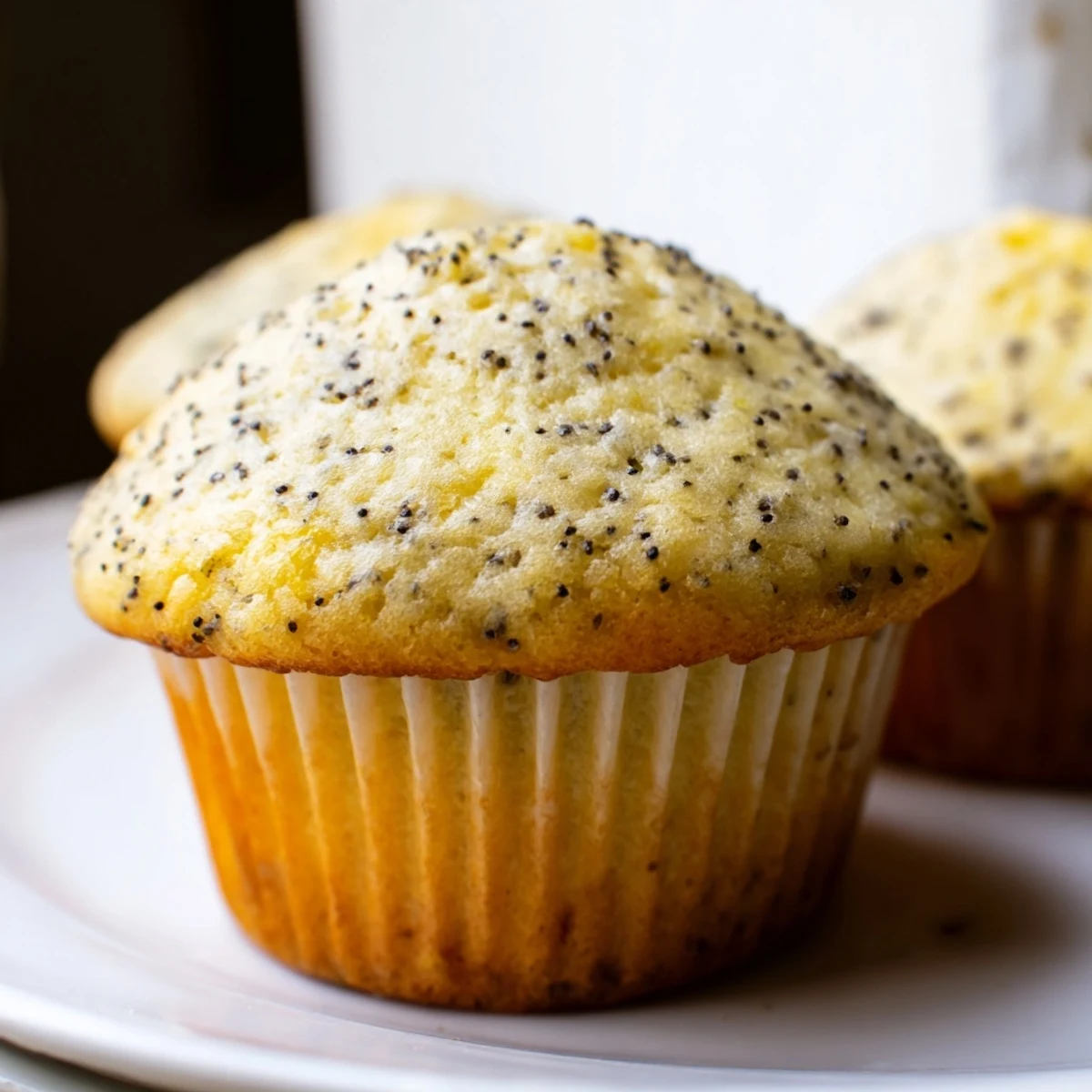 Golden lemon poppy seed muffins with domed tops fresh from the oven
