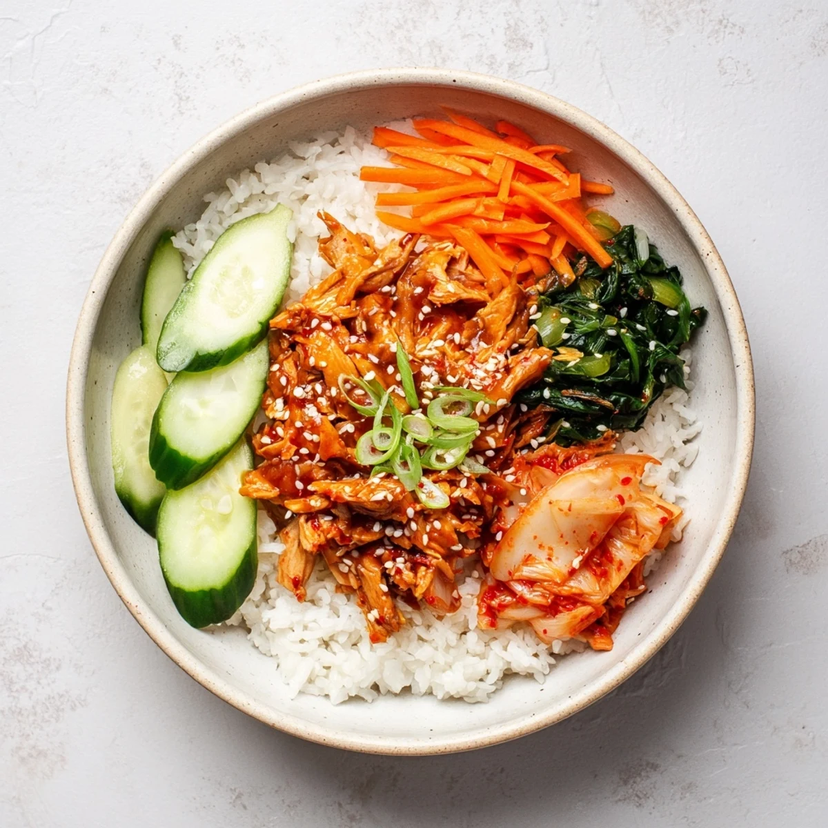 Vegan tofu bulgogi bowl topped with saucy crispy shreds and fresh kimchi