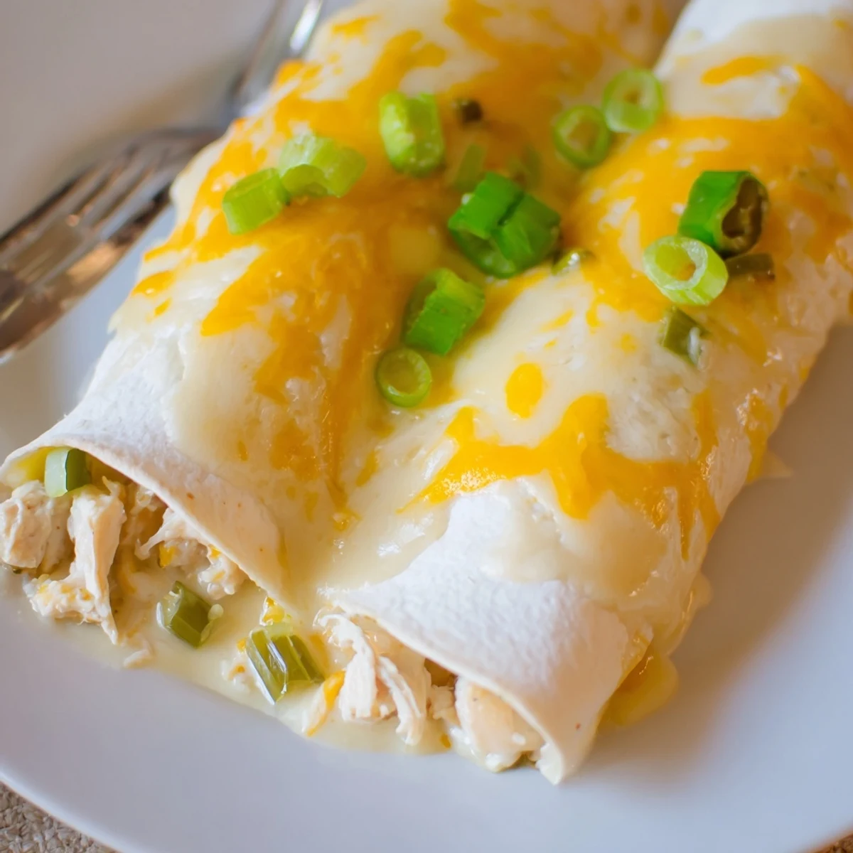 Tray of Creamy White Chicken Enchiladas with velvety white sauce and melted cheese  
