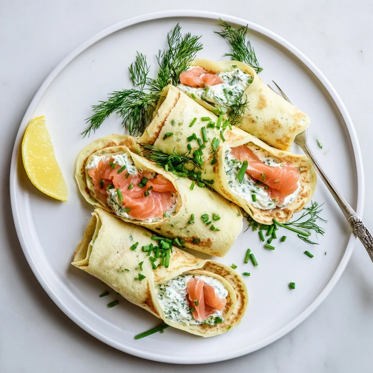 Golden rolled smoked salmon crepes recipe filled with creamy herbed cheese and fresh dill