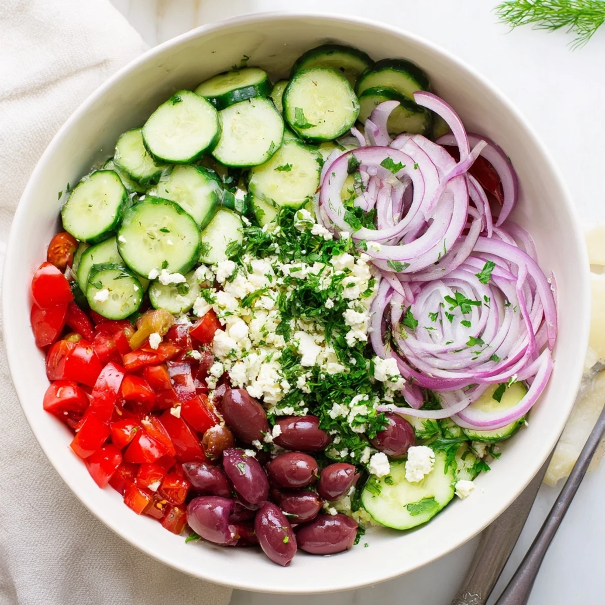 Fresh Mediterranean cucumber salad with crisp vegetables, feta cheese, and bright herbs in a serving bowl.