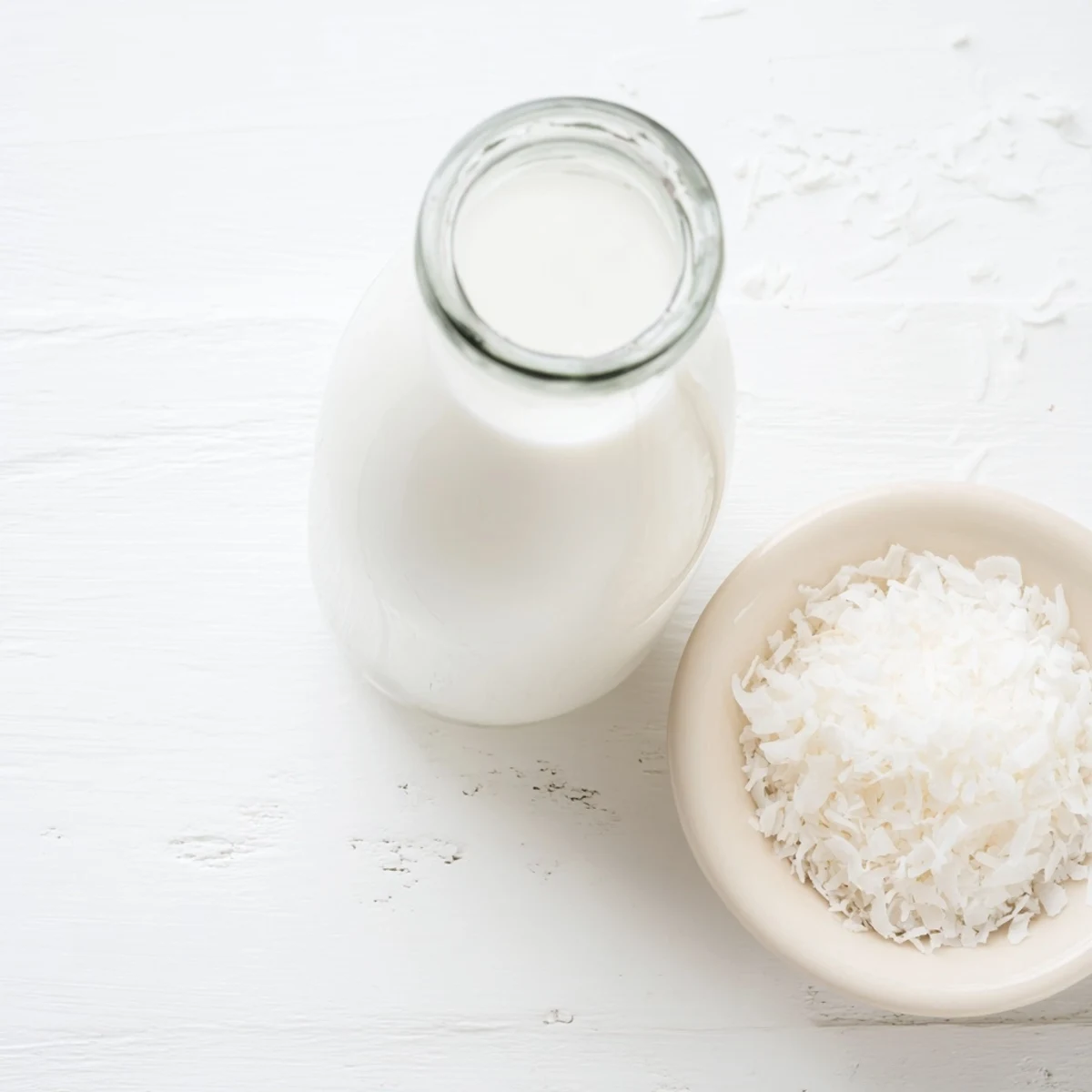 Creamy homemade coconut milk recipe displayed in clear glass bottle on counter