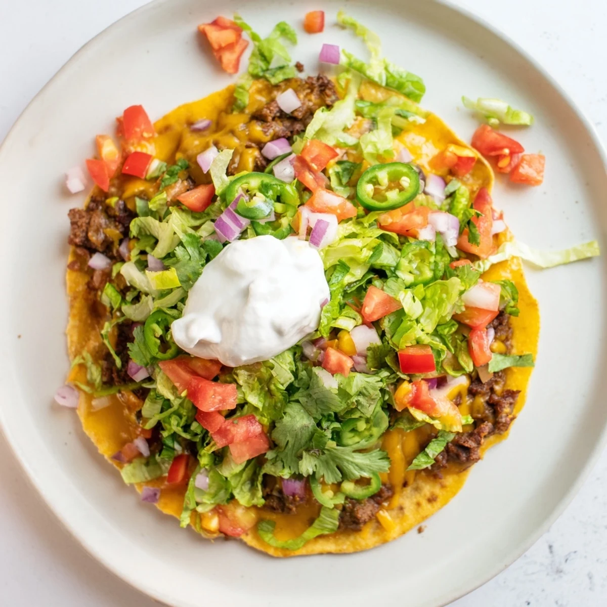 Sizzling Blackstone smashed beef tacos featuring bubbling cheese, crisp tortilla edges, and colorful garnishes
