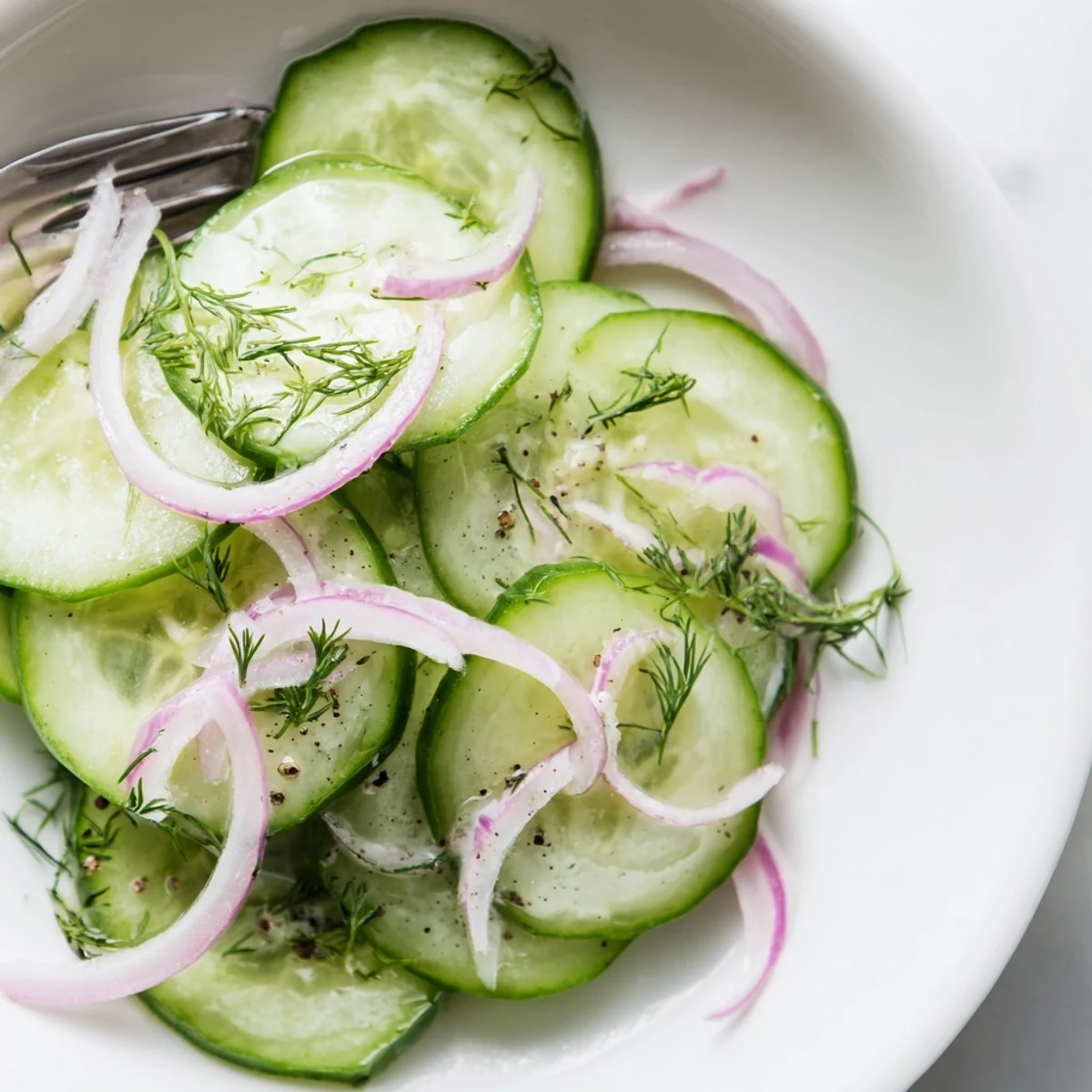 Cucumber Salad glistening with dill and vinaigrette, chilled in bowl