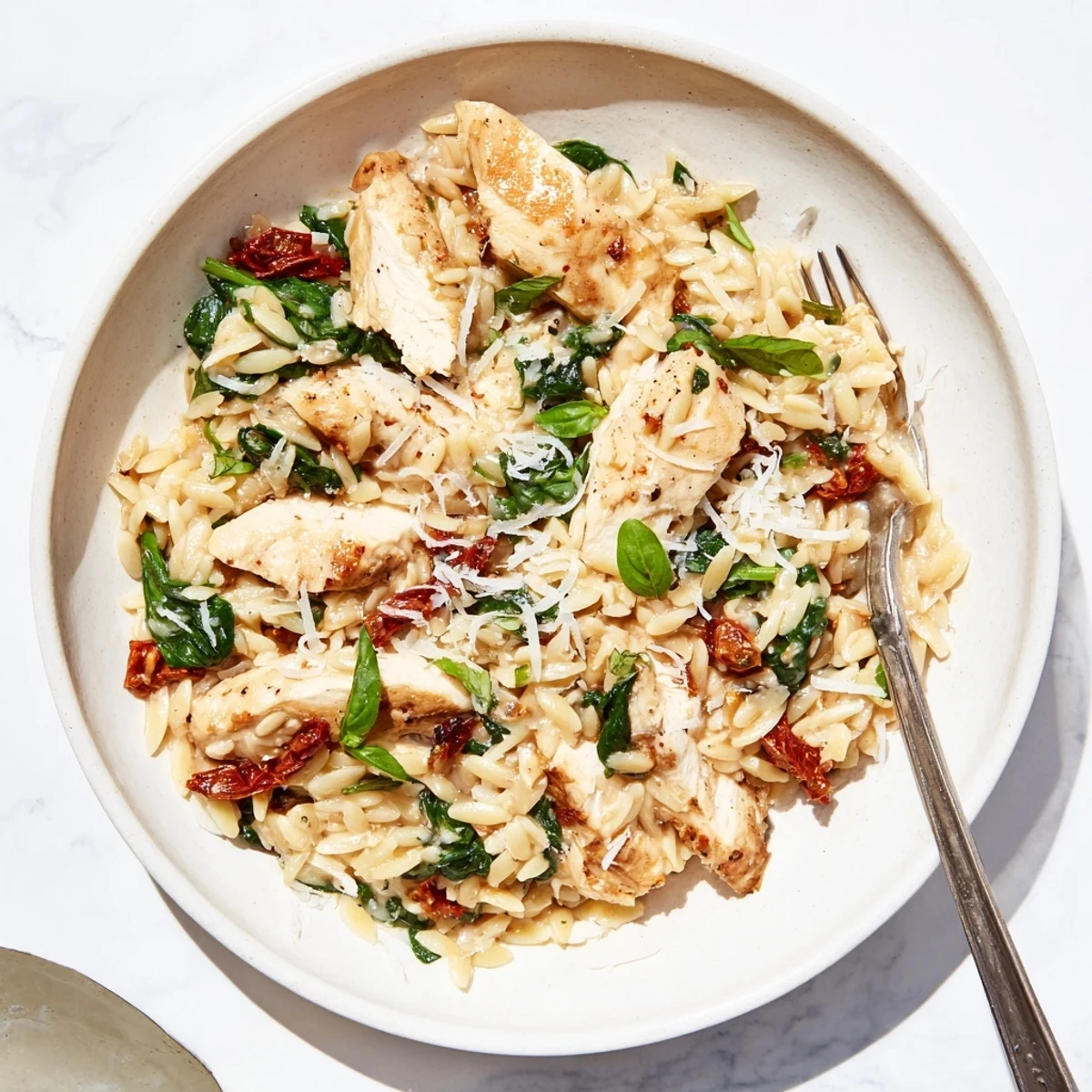 One-pot Marry Me Chicken Orzo dish topped with fresh Parmesan and fragrant basil garnish
