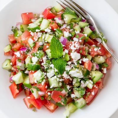 Bowl of Turkish Shepherds Salad garnished with crumbled feta and Kalamata olives