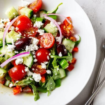 Colorful Fresh Salad Recipe featuring arugula, feta crumbles, tangy Dijon honey vinaigrette.